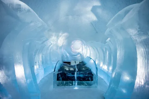 bed and ice sculptures inside art suite in icehotel 365
